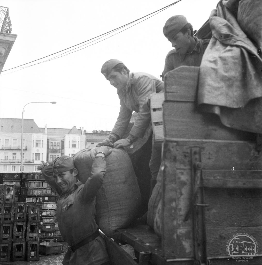 Soldații descarcă ajutoare pentru sătmăreni / Segélycsomagokat lerakodó katonák